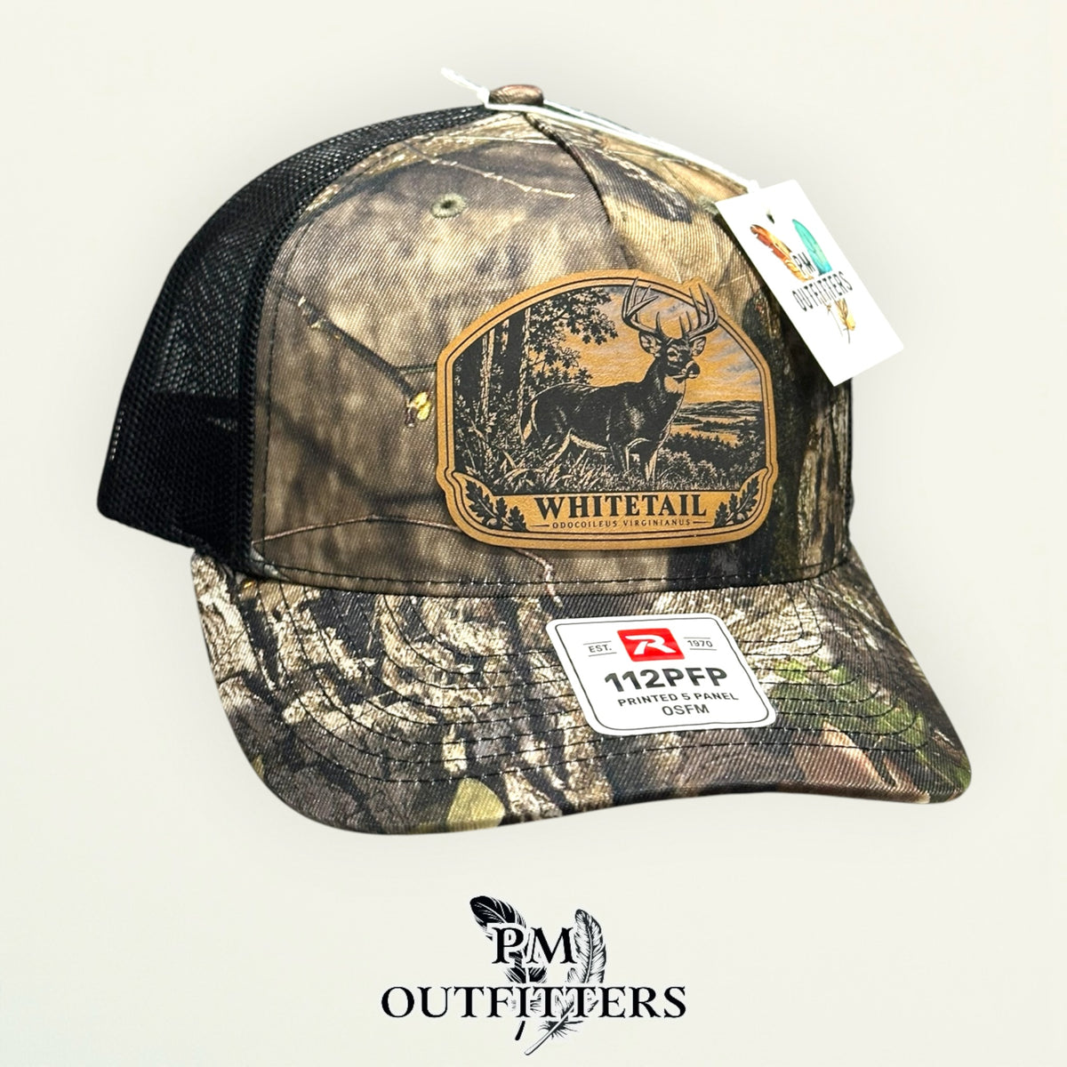 Whitetail buck leather patch camo trucker hat – left angle showing black mesh back